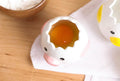 Chicken-shaped egg separator releasing egg white into a bowl